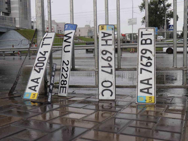 В Киеве на «Левобережке» из озера на дороге выловили кучу номерных знаков (фото, видео)